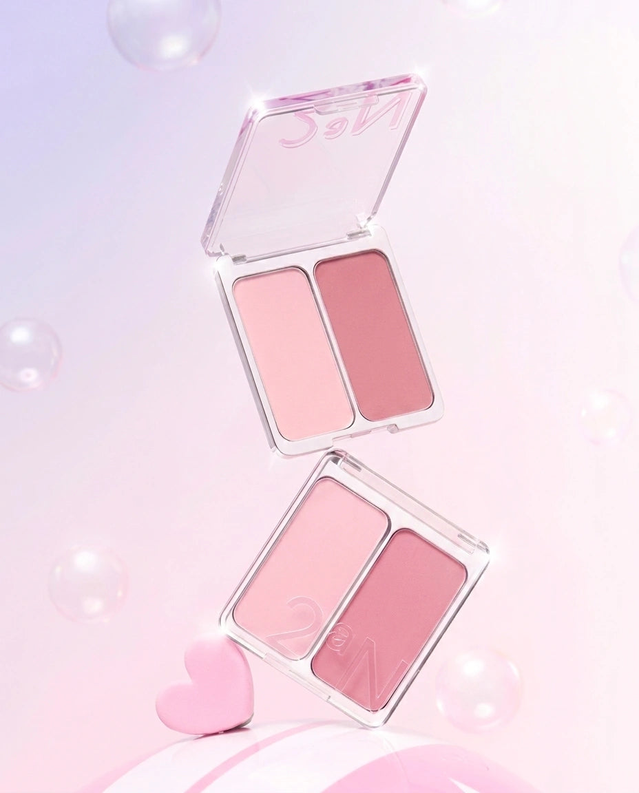 Two open square makeup palettes with two pink shades each, arranged vertically on a soft pink background with floating bubbles and a small pink heart.
