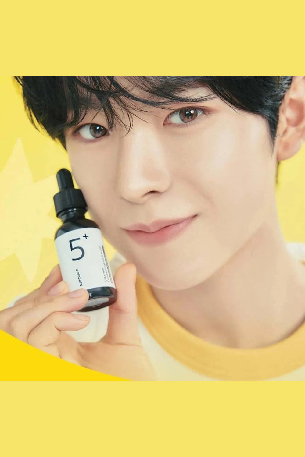 Person holding a skincare product with a yellow background