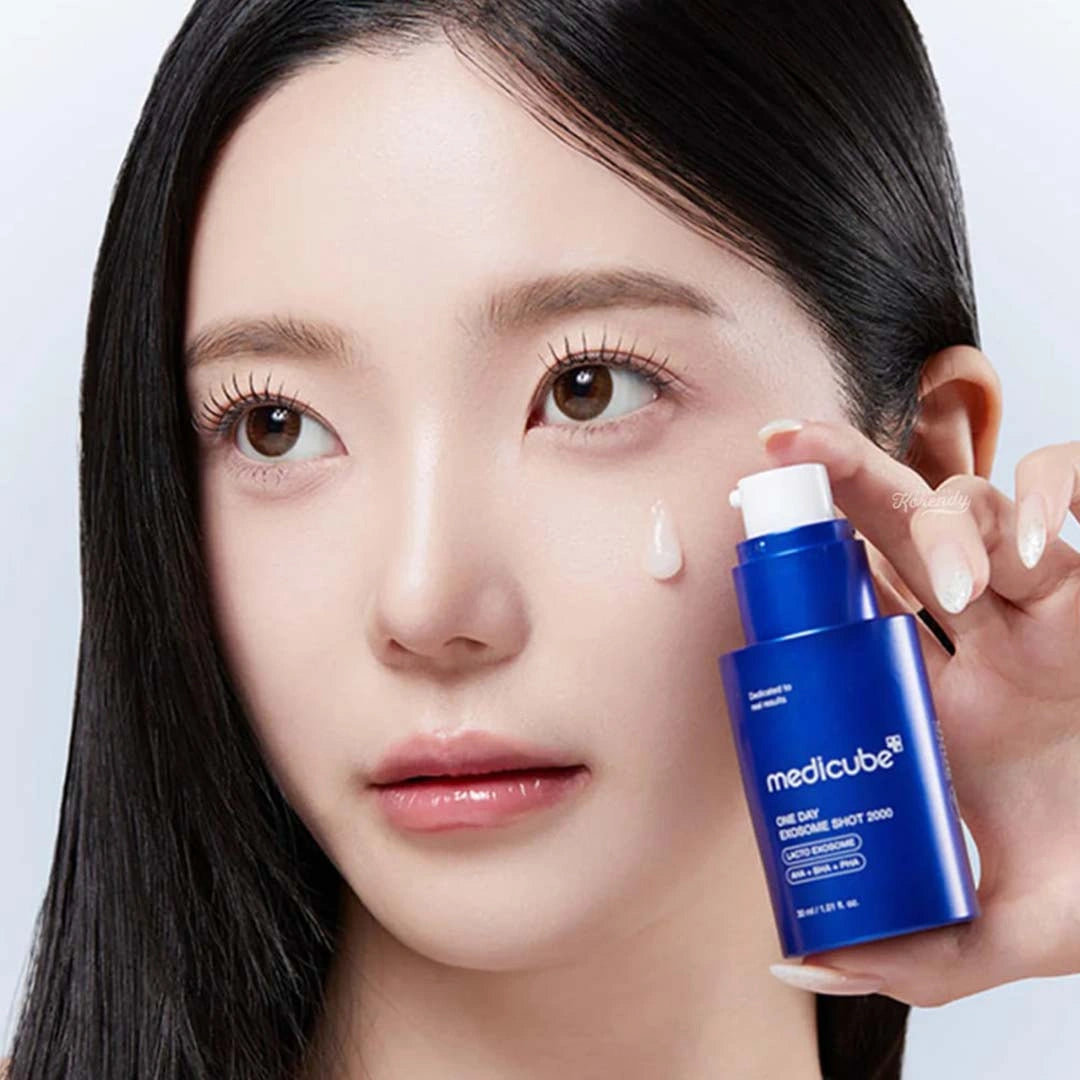 Woman applying a blue skincare product to her face with a white background