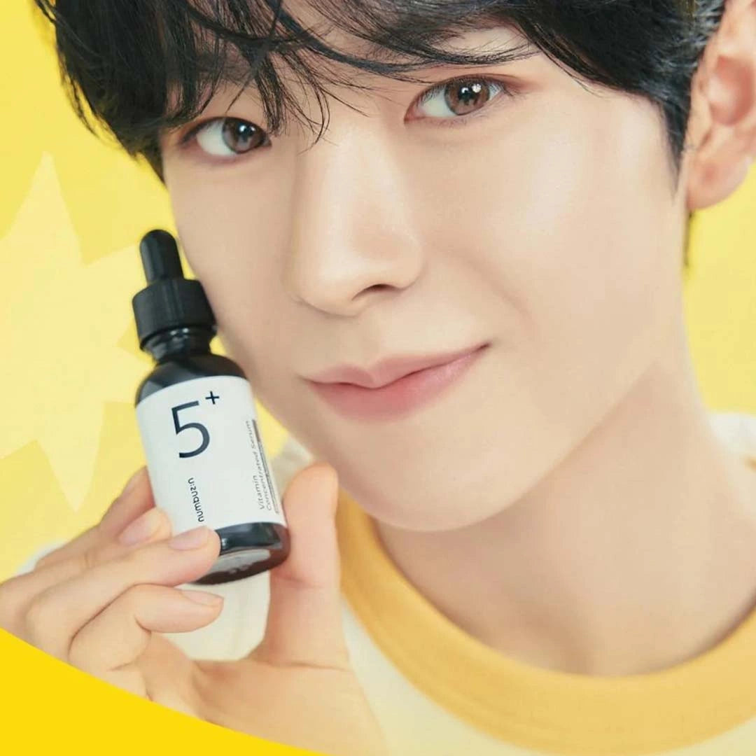 Person holding a skincare product with a yellow background