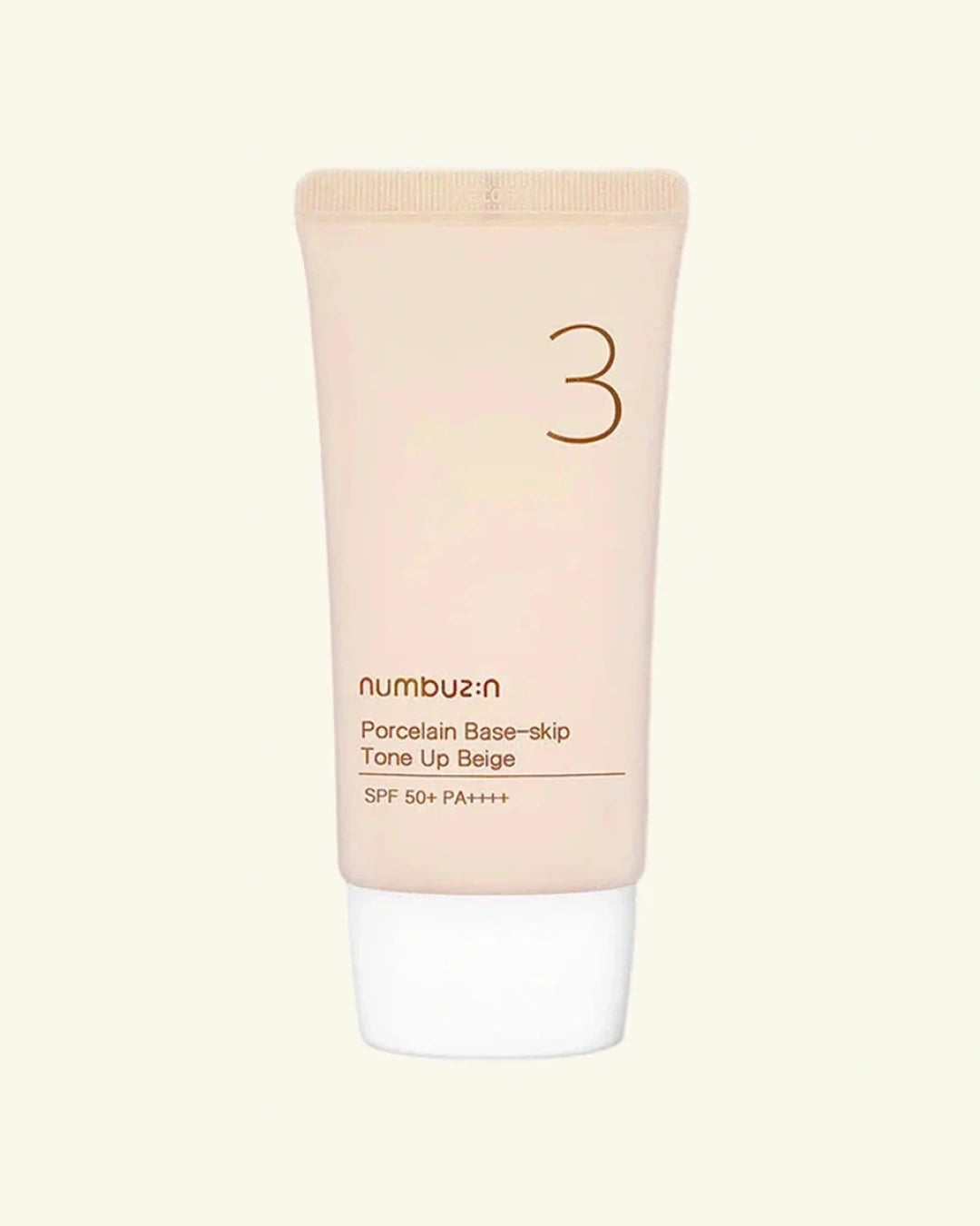 A squeeze tube of numbu:n Porcelain Base-skip Tone Up Beige SPF 50+ PA+++ sunscreen, featuring a pale peach-beige body with a white cap, centered on a light cream background.