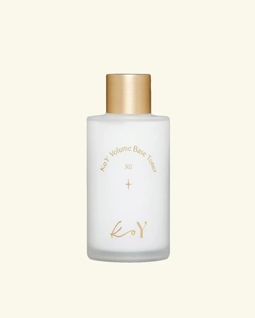 A frosted glass bottle of Koy Volume Base Toner with a metallic gold cap and gold lettering, centered on a solid cream background.