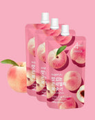 Three pink stand-up pouches of sugar-free peach jelly drink with white caps, shown on a solid pink background with peach illustrations and a whole peach graphic at the lower left.