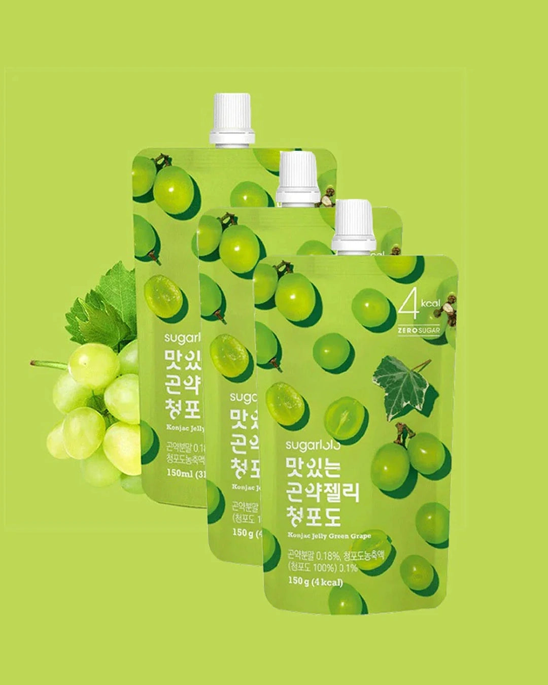 Three sugarlab grape juice pouches arranged in a fan shape on a light green background, with a bunch of green grapes on the left side. The pouches are light green with a pattern of green grapes and white caps.