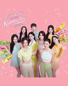 A promotional group photo featuring nine women posing together against a pink background with bubble graphics and Korean text reading 'Let's Drink Twice! I've Been Drinking Kombucha' and 'Kombucha' on colorful sticks. No single packaged product is isolated, and the scene functions as a branded promotional/lifestyle-style graphic rather than a clean product shot.