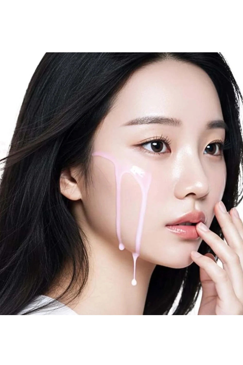 Woman with black hair and minimal makeup, holding her chin with one hand.