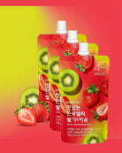 Three stand-up pouches of sugarbaba fruit-flavored drink mix, shown with strawberry and kiwi graphics on the packaging against a red-to-yellow gradient background with loose strawberries and kiwi slices around them.