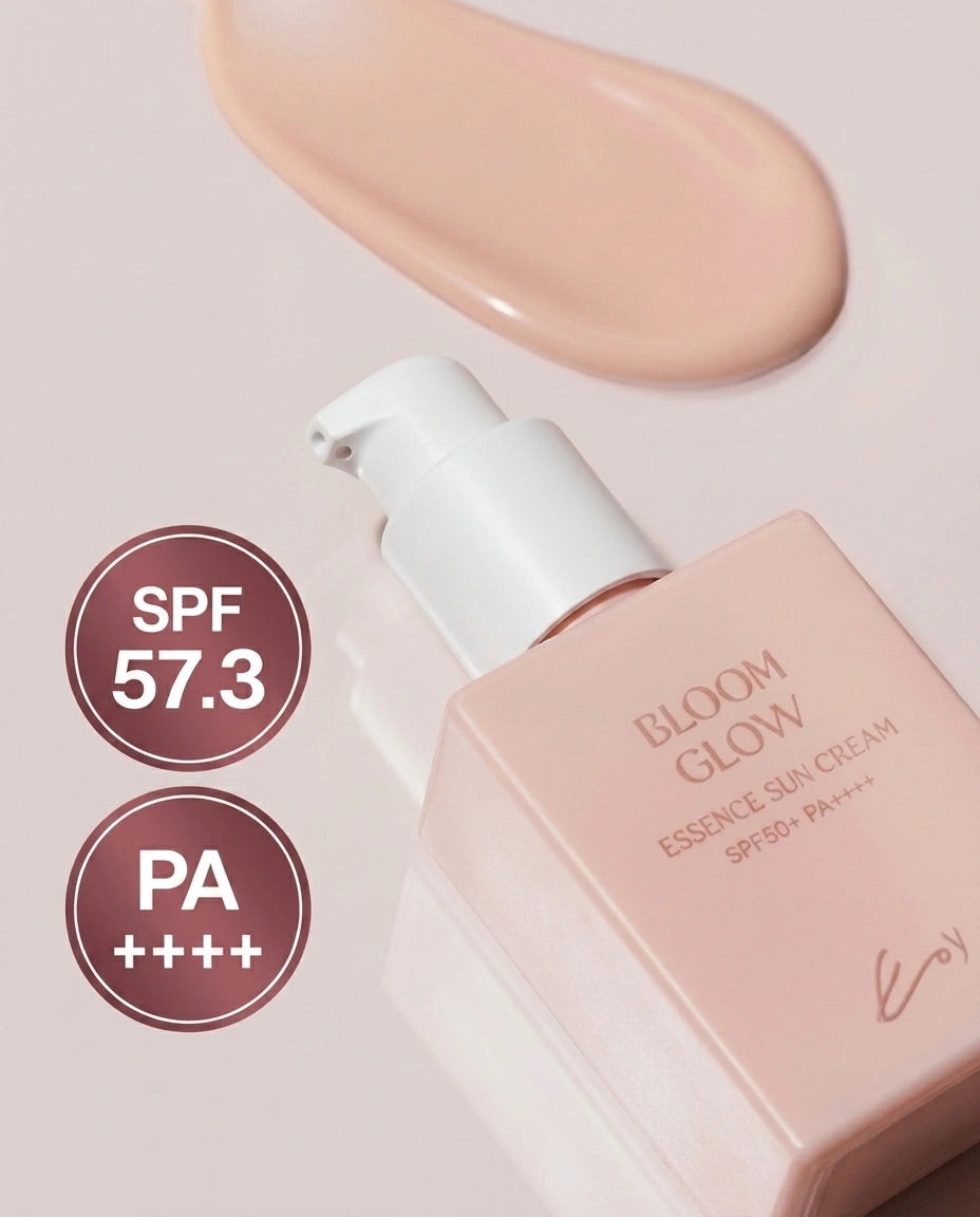 A bottle of Bloom Glow Essence Sun Cream SPF 50+ PA++++ in a soft peach-pink shade, shown with a matching cream swatch above it and circular badges indicating SPF 57.3 and PA++++.