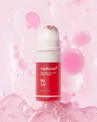 A bottle of medicube Pink Collagen Bubble Serum centered against a pink background with liquid droplets and bubbles. The bottle is red and white with the brand name 'medicube' and product text clearly visible.