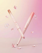 Two pink and white dual-ended lip liner pencils crossed on a soft pink background with floating cherry petals and bubbles. The brand name 'Shapppa' and 'DualLiner' are visible on the packaging.