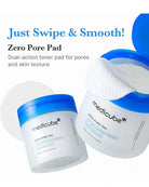 Medicube Zero Pore Pad shown in two white jars with blue lids on a white background, with one jar open to reveal white round pads and text reading 'Just Swipe & Smooth!'.