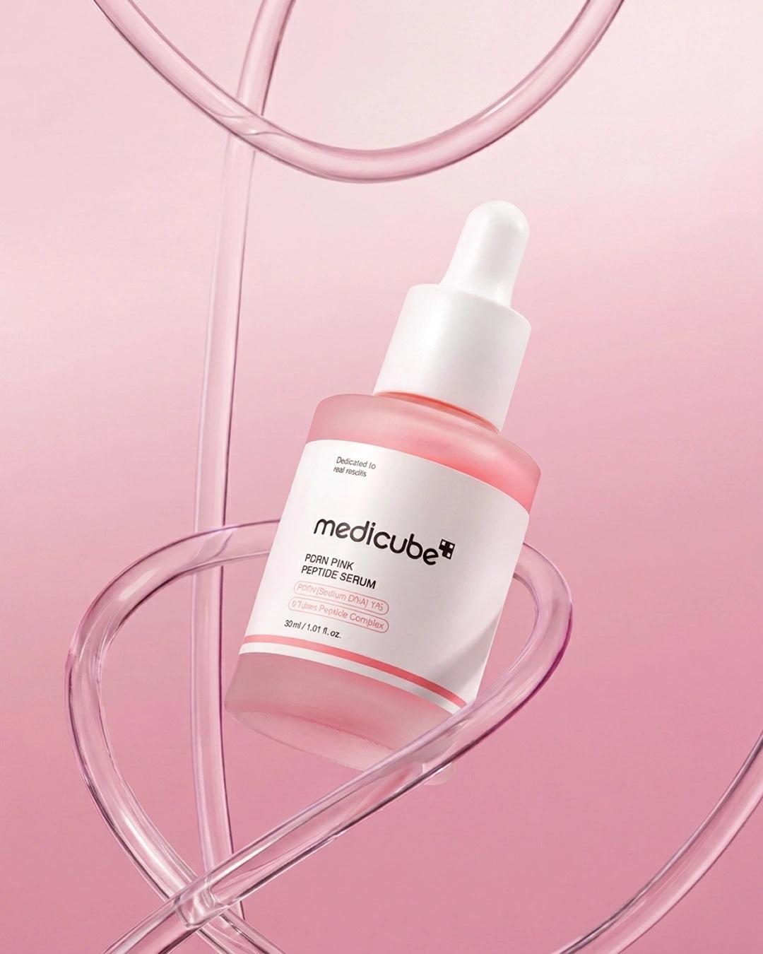 Medicube Pion Pink Perfume Serum in a frosted glass dropper bottle with a white label and white dropper cap, set against a soft pink background with abstract curved transparent lines.