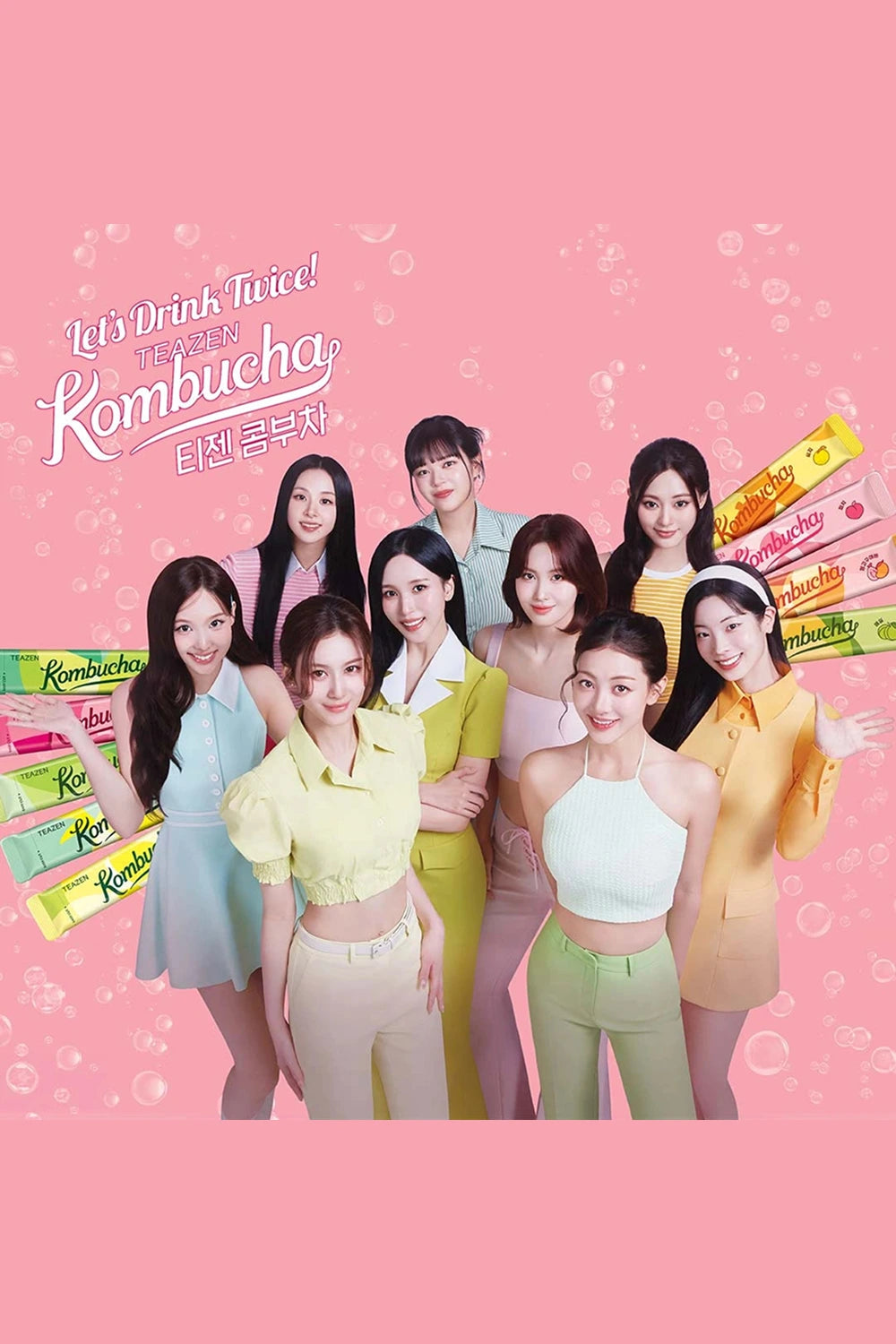 Group of women posing with Kombucha products on a pink background