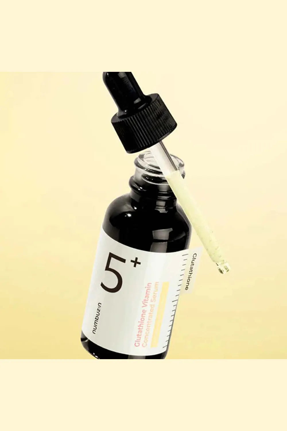 Bottle of skincare serum with dropper on a beige background