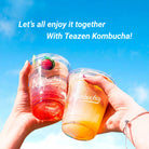 Two hands holding kombucha cups with a blue sky background and promotional text for Teazen Kombucha.