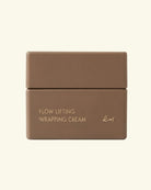 A matte brown cosmetic jar with a matching lid, labeled 'FLOW LIFTING WRAPPING CREAM' in gold lettering, set against a solid cream background.