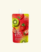 A stand-up pouch of zero sugar strawberry and kiwi recipe jelly drink, featuring a red and yellow label with illustrations of strawberries and kiwi slices, on a light cream background.