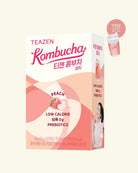 A box of TEAZEN Kombucha Peach flavor, featuring pink and peach graphics, a peach illustration, and a small promotional badge indicating a free prebiotic cup.