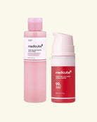 Two Medikube skincare bottles on a light cream background: a pink toner bottle on the left and a red serum pump bottle on the right.