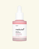 Medicube Poin Pink Peptide Serum in a frosted glass dropper bottle with a pink liquid and a white label, set against a solid pale cream background.